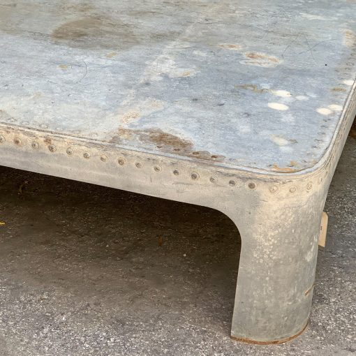 Antique galvanized metal coffee table, top right corner